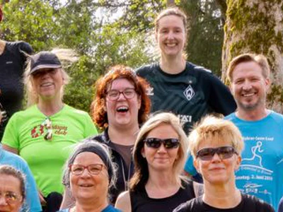 Lachende Mitglieder des ausdauerclub in Club-Shirts