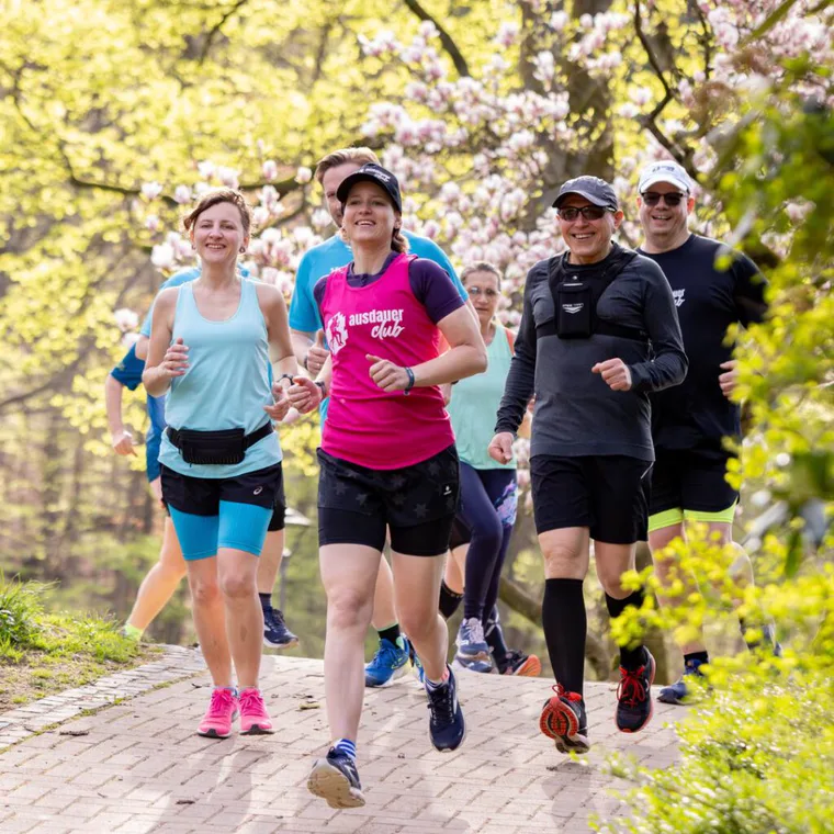 Laufgruppe des ausdauerclub unter blühenden Bäumen